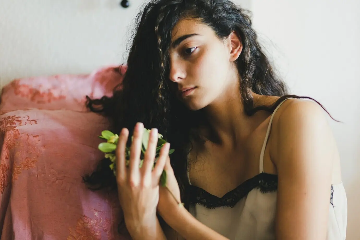 Eine junge Brünette hält zerbrechliche Blumen.